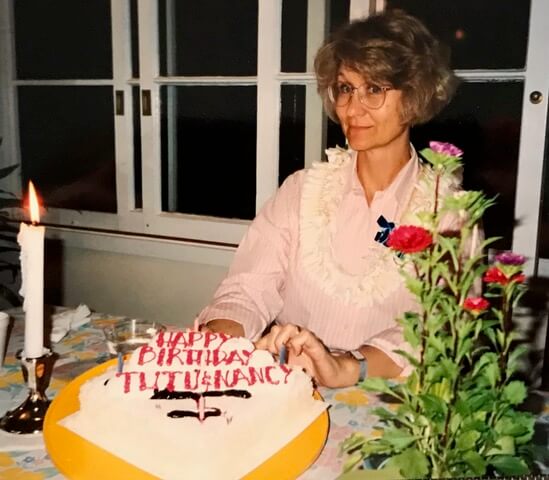 Woman sitting in front of birthday cake