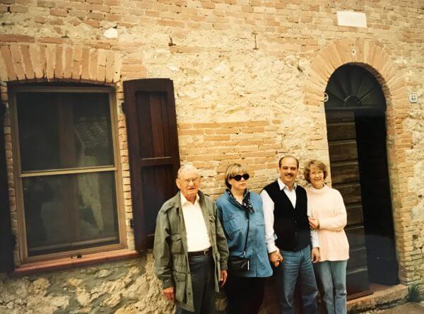 photo of four people in front of a building